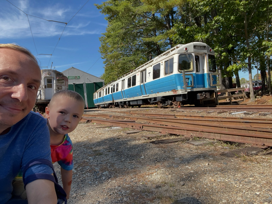 My nephew and I look on as the MBTA blue line trains from the 80s 90s and early odds is parked outside a car house. These are the blue bells.