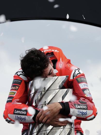 Marc Marquez abrazando el trofeo de campeón del mundo de MotoGP.