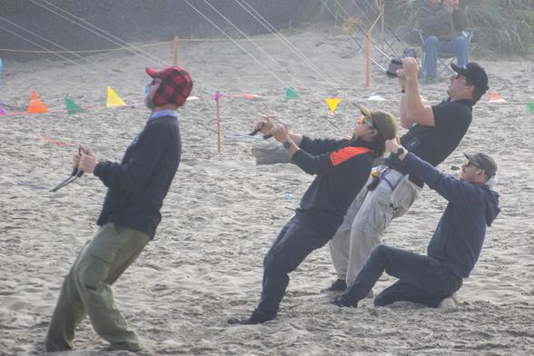 The kite fliers flying the stacks resisting the significant pull that the stacks generate