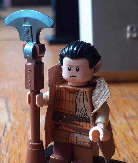 A LEGO minifigure of a Vulcan Desert Guard, holding a classic "Lirpa"