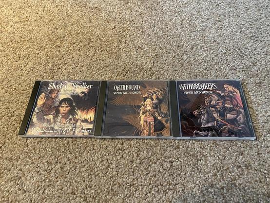 Three Valdmar book soundtrack CDs laid out on the floor.
From left to right:
Shadow Stalker: Songs from Vanyel’s Time
Oath Bound: Vows and Honor
Oath Breakers: Vows and Honor