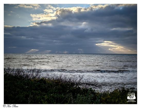 View of the Indian Ocean from the Bunbury coast, with heavy, low clouds and bright shafts of light shining down onto the choppy water.