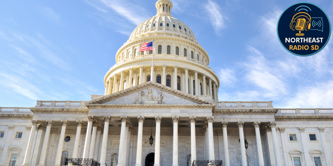 US Capitol with flag waving under a clear blue sky. Northeast Radio SD logo in the corner. Classical architecture, grand and serene.