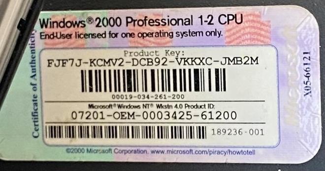 An image of a Windows 2000 Professional product key certificate, featuring the product key, a barcode, and related licensing information. The certificate indicates it is licensed for one operating system only and includes a Microsoft logo with the year 2000.