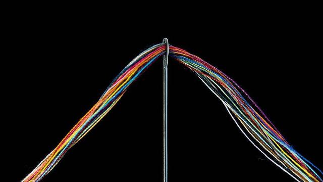 Thread going through a needle.