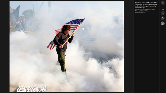 PHOTO: A protester carries a US flag through tear gas launched to clear protesters outside the Broadview immigration processing centre in Chicago.

Photograph: Stacey Wescott/Chicago Tribune/TNS/ZUMA Press Wire/Shutterstock
