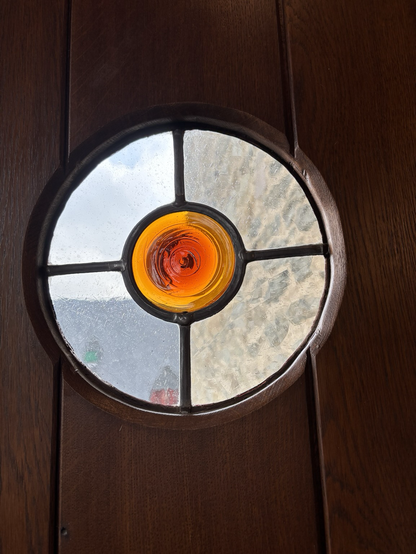 Rundes bleiverglastes Butzenfenster in einer Burg. 