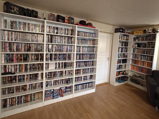 Foto av videoveggen min. Fem bokreolar fylt til randen med videofilm.