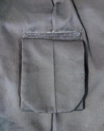 Black cargo pocket covered by a flap that is too large.