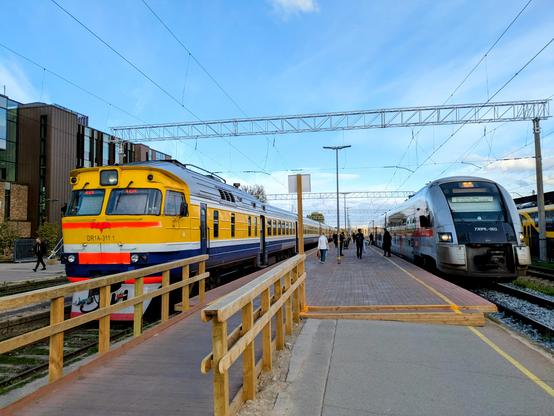 Zwischenhalt des Pesa-Triebwagen von LTG-Link in Riga. Am Gleis gegenüber steht ein alter Dieseltriebwagen von Vivi.