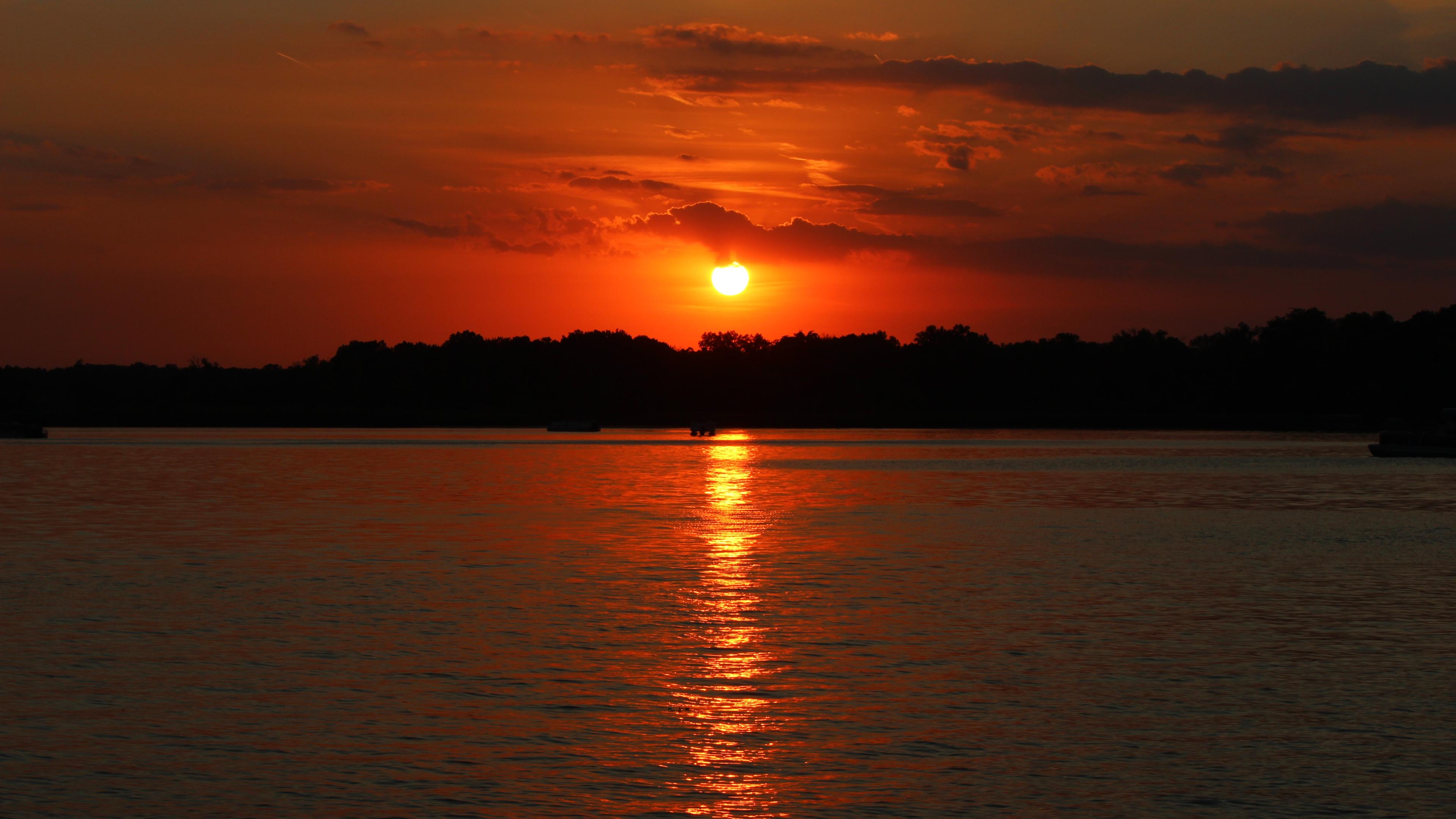 Sunset photo of a Sun setting over a lake in a dark red sky, taken at 55mm, f/10, ISO 100, 1/250 sec. Sunset photo of a Sun setting over a lake in a dark red sky, taken at 55mm, f/10, ISO 100, 1/250 sec.