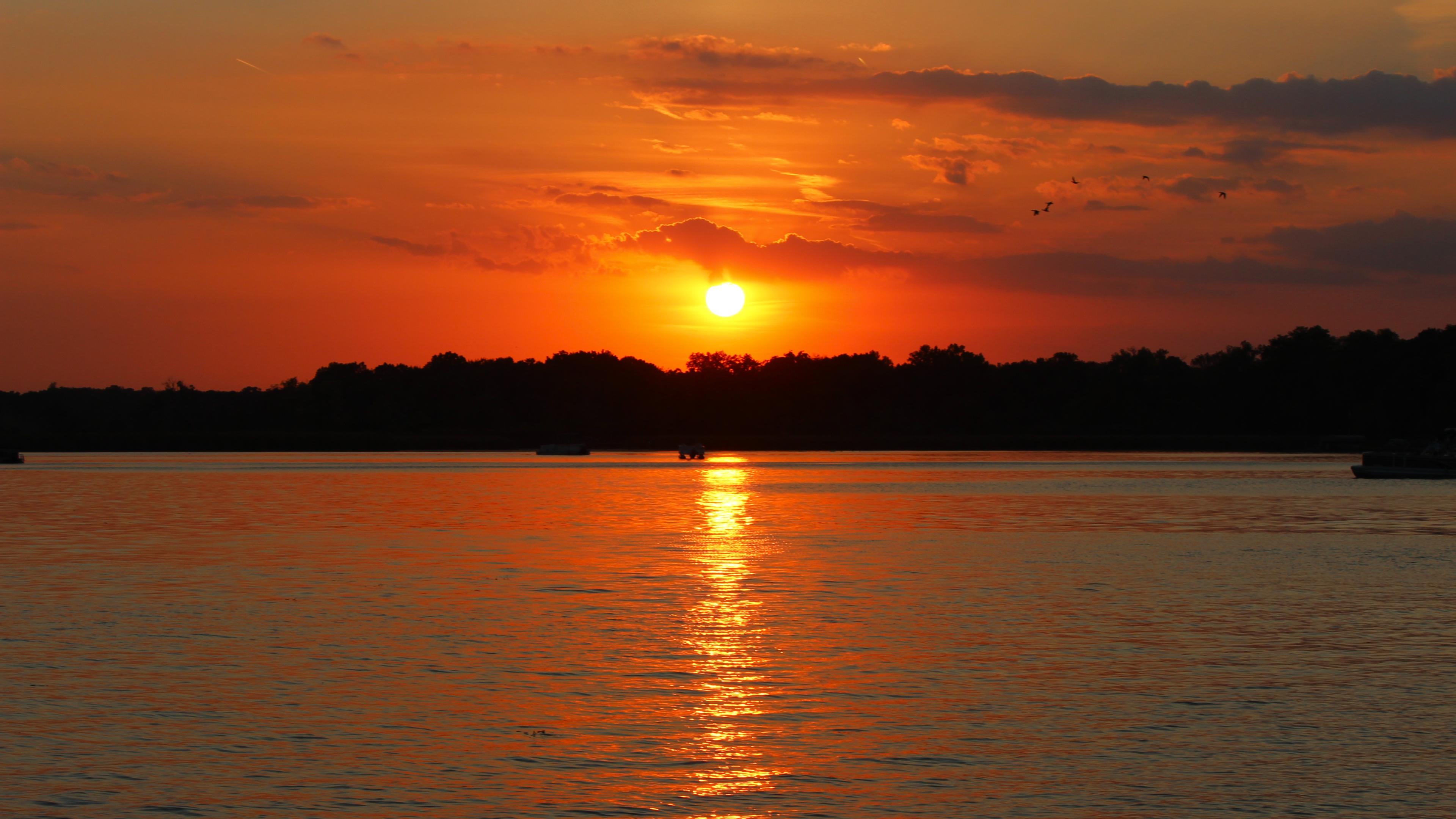 Sunset photo of a Sun setting over a lake in a dark red sky, taken at 55mm, f/10, ISO 100, 1/200 sec. Sunset photo of a Sun setting over a lake in a dark red sky, taken at 55mm, f/10, ISO 100, 1/200 sec.