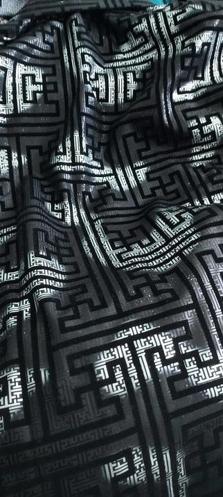 Black and silver fabric with an angular velvet pattern that may or may not look like swastikas