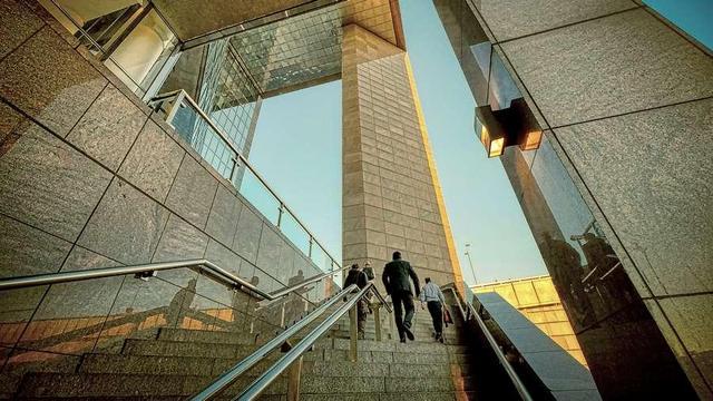 People walking up stairs in city building.