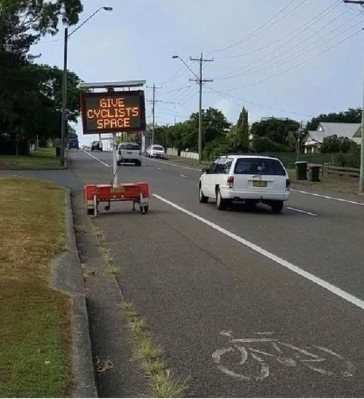 Temporary sign reads: GIVE CYCLISTS SPACE blocking cyclist lane