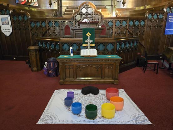 7 crystal singing bowls on the ground in front of a pulpit in a church