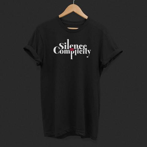 Schwarzes T-Shirt mit dem weißen Slogan „Silence is Complicity“ in Serfifenschrift. Das Wort „is“ ist durch ein rotes "ist-gleich-Zeichen" ersetzt, das mittig zwischen den beiden Worten steht und wodurch der Satz grafisch betont wird. Das Design steht für Zivilcourage und die Botschaft, dass Schweigen gegenüber Ungerechtigkeit Mitschuld bedeutet.
