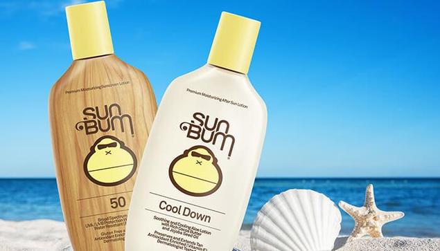 Two bottles of Sun Bum sunscreen and after-sun lotion placed on a sandy beach with seashells, highlighting the question: Is Sun Bum Sunscreen Safe?