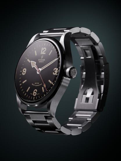 A photorealistic render of a Tudor Heritage Ranger watch. The watch is seen from 3/4 face and rendered on a greenish background. 
