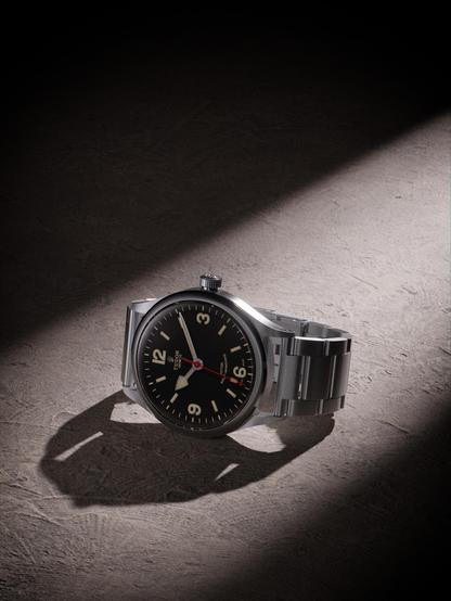 A photorealistic render of a Tudor Heritage Ranger watch, rendered on a empty floor with minimalistic lighting.