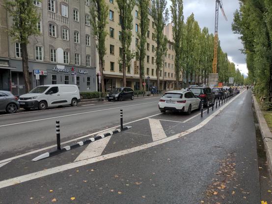 Poller zwischen Parkstreifen und Radweg.