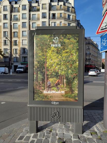 L'image montre une publicité dans un panneau publicitaire à Paris. Le panneau affiche un paysage urbain, avec une promenade verdoyante où deux personnes se trouvent. L'une marche, l'autre fait du vélo. Le logo "Ville de Paris" est visible en haut. En arrière-plan, on peut voir un immeuble parisien typique, et des voitures circulent dans la rue. Le jour est ensoleillé.