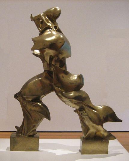 a sculpture resembling a large drifting torso and legs, moving to the left, a representation of bipedal movement in an abstract way, the sculpture  is bronze gold 