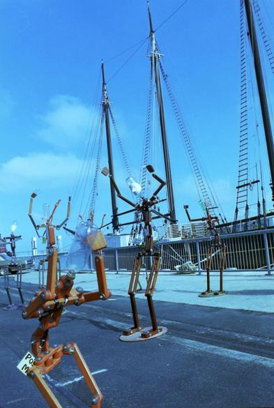 metal people in front of big boat