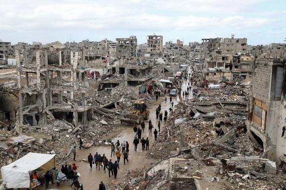 Les Palestiniens passent devant les décombres de bâtiments détruits.