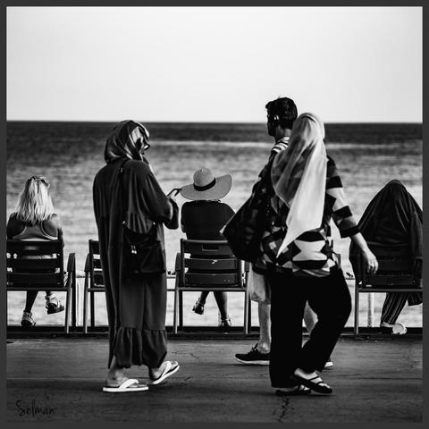 Contemplating Serenity. People sitting and relaxing in beach chairs in Nice, Provence. Black and white street photography. Copyright Silvijo Selman.