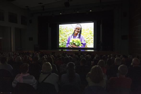 Michael vor großer Leinwand mit dem Bild einer Rosen-Pflückerin