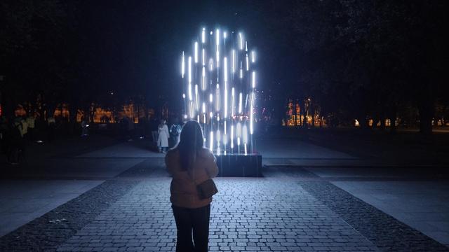Light Move Festival 2025 in Łódź - The Kinetic Art of Light Festival: silhouette of a girl against color-changing light sculpture.