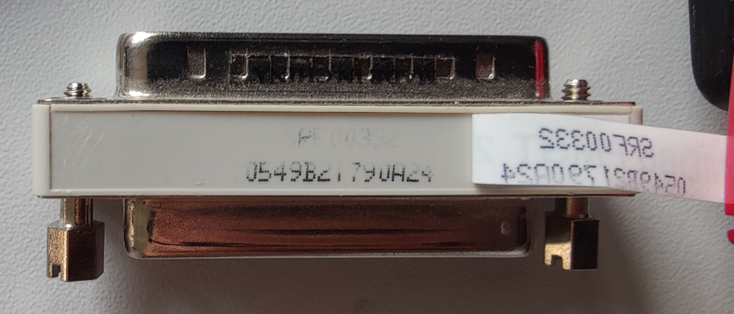 Parallel port passthrough dongle with what is supposedly a product code ( SRF00332) and serial number.
