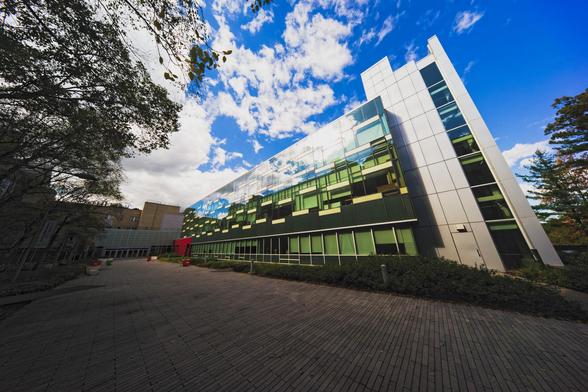 Modern has the close end on right seeming to bend away from us and receedes to the left with an elaborate glass facade that reflects a blue and white cloudy sky above