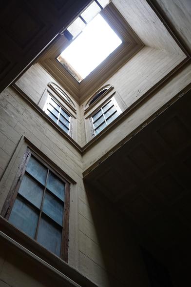 Photo d'anciennes fenêtre qui donnent sur une sorte de cour très étroite (genre 2m x 3m) à ciel ouvert