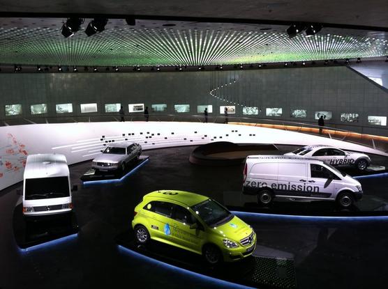 Interior view: various vehicles on display, including a delivery van with the text ‘zero emission’