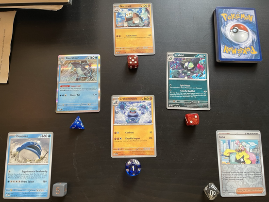 Cards from Pokemon and an accompanying dice in an oracle reading.