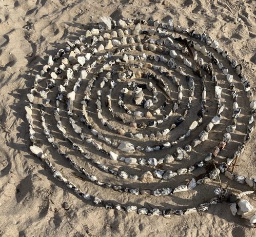 Flintsteine spiralförmig in den Sandstrand gedrückt.