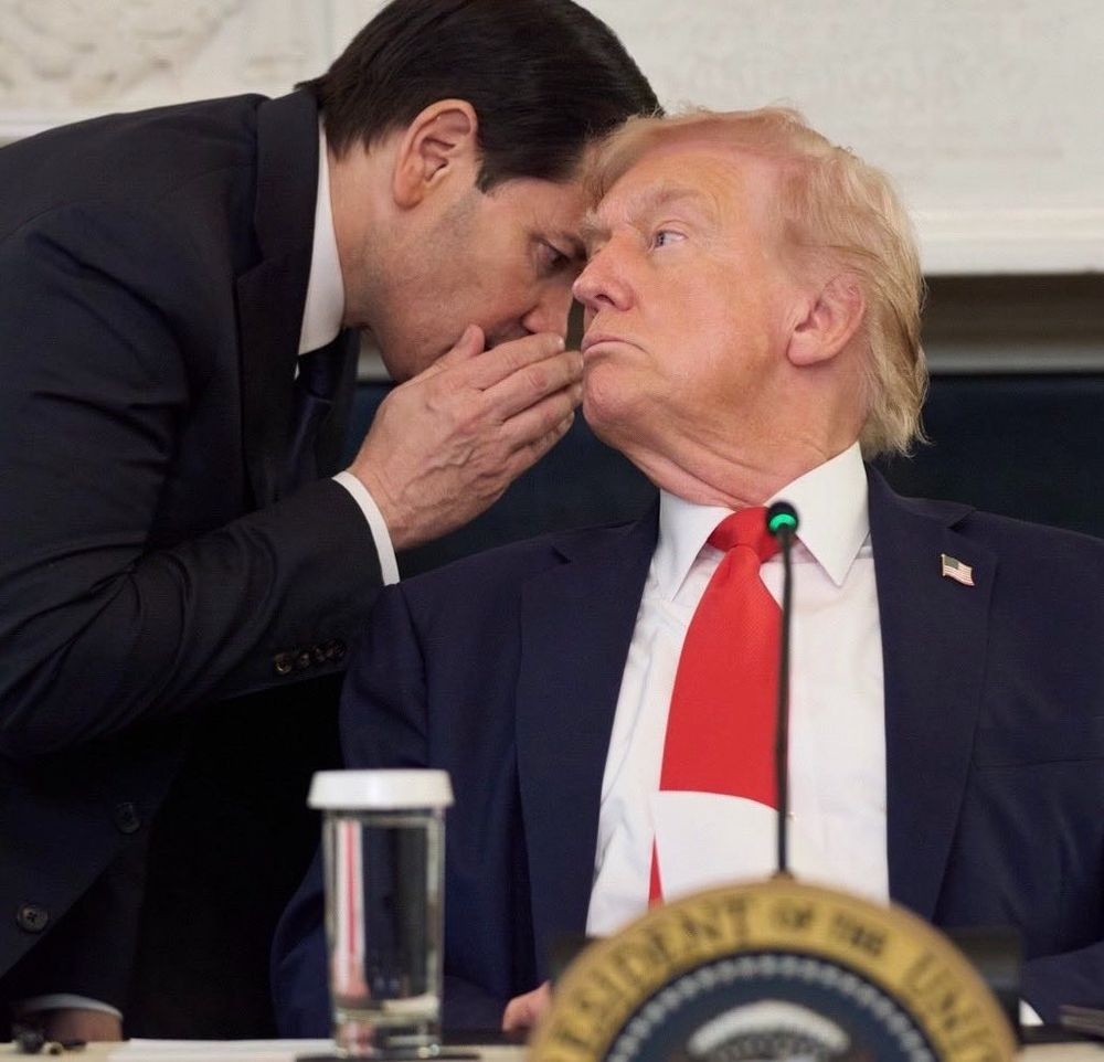 Marco Rubio whispers into Donald Trump's ear.