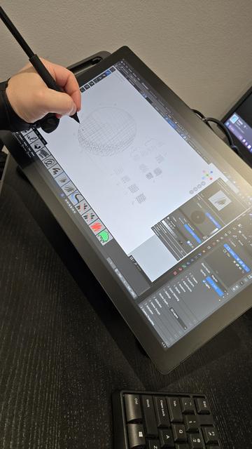 Cintiq with Blender on interface, a left hand wearing a smudge guard, holding a Pro pen 3