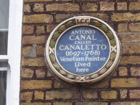 Romanesque, circular, blue plaque and words stating that Canaletto lived in the house on which it is placed.