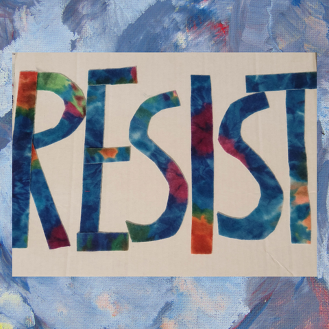 A colorful sign is featured that includes the word RESIST on it.