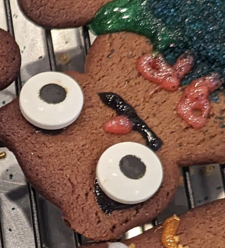 Slightly burn cat cookie with way oversized eyes and a 👁️_👁️ expression.