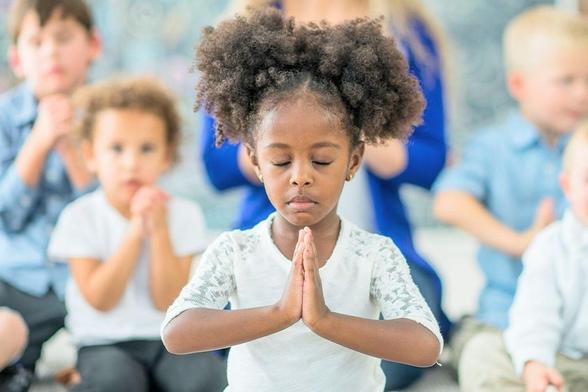 *A picture of a bunch of little children praying and focused on an adorable little girl in front in intense prayer