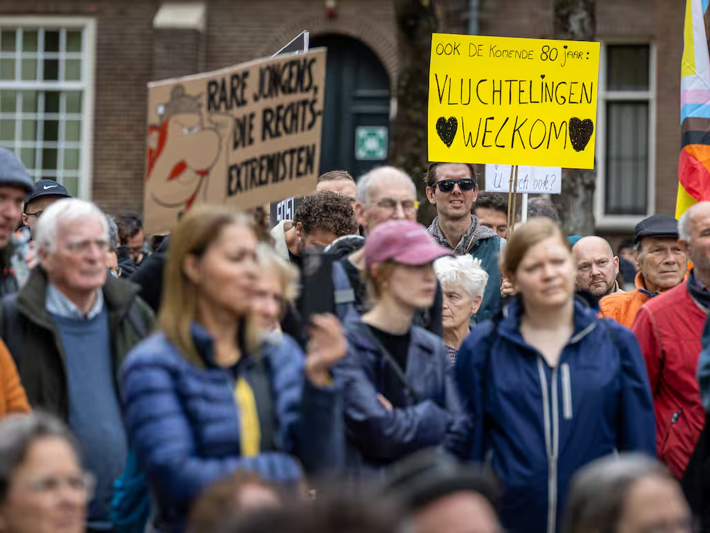 Foto van een groep tegendemonstranten van de anti-immigratie demonstratie, met spandoeken als "Ook de komende 80 jaar vluchtelingen welkom" en een bord met een afbeelding van Obelix, met de tekst "rare jongens die rechtsextremisten"