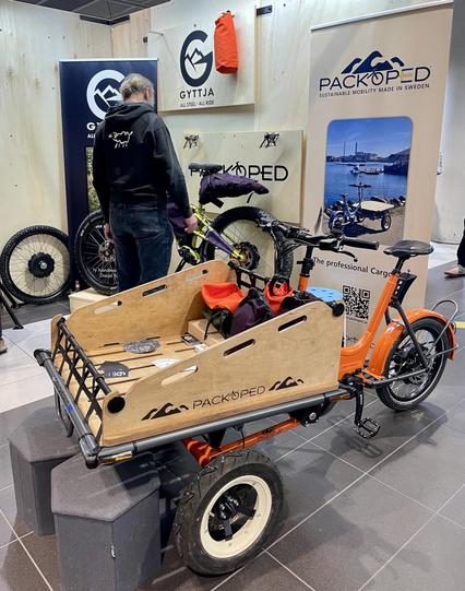 Stand der Firma packoped mit orangefarbenem Lastenrad, im Hintergrund
