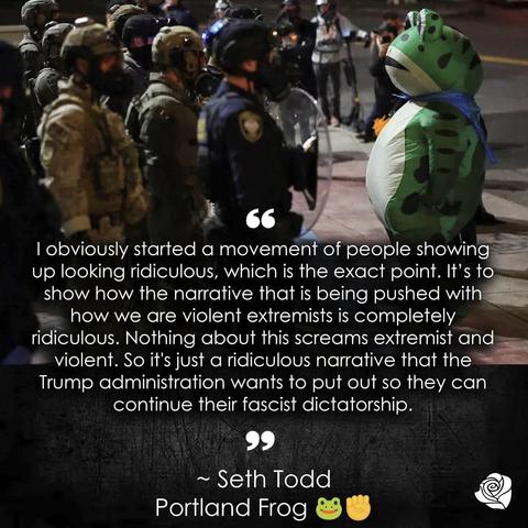 The image depicts the Portland 🐸 ,(the now famous inflatable suit) standing in front of a large group of tactical ICE creeps. The photo was taken in the late hours of the night or early hours of the morning as it is very dark out. Beneath and across the image is a quote that reads: 
“I obviously started a movement of people showing up looking ridiculous, which is the exact point. It's to show how the narrative that is being pushed with how we are violent extremists is completely ridiculous. Nothing about this screams extremist and violent. So it's just a ridiculous narrative that the Trump administration wants to put out so they can continue their fascist dictatorship.”
~ Seth Todd
Portland Frog 🐸 ✊