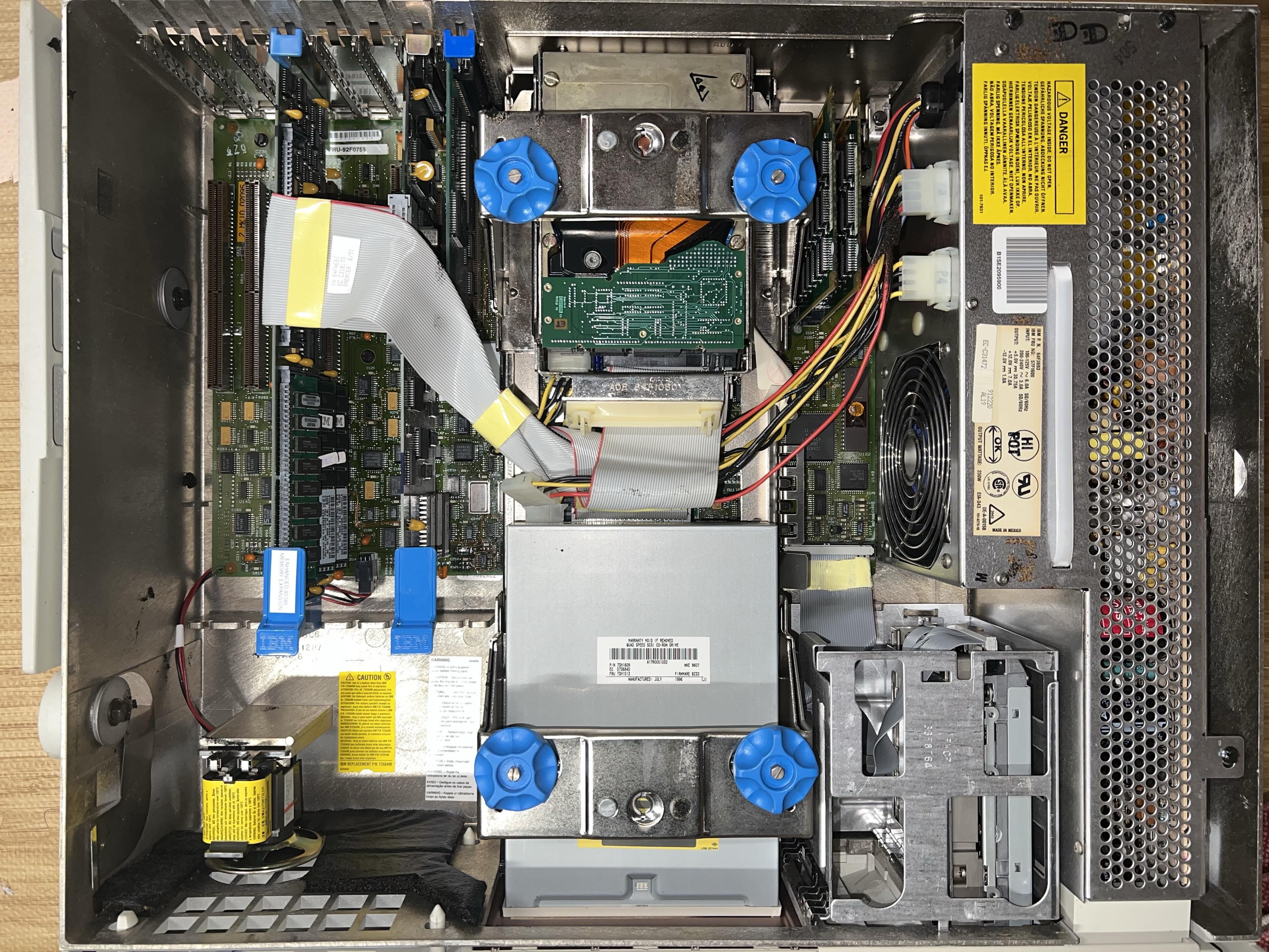 The inside of the IBM 8580 PC showing some cards plugged into a motherboard below and cables neatly running between components.