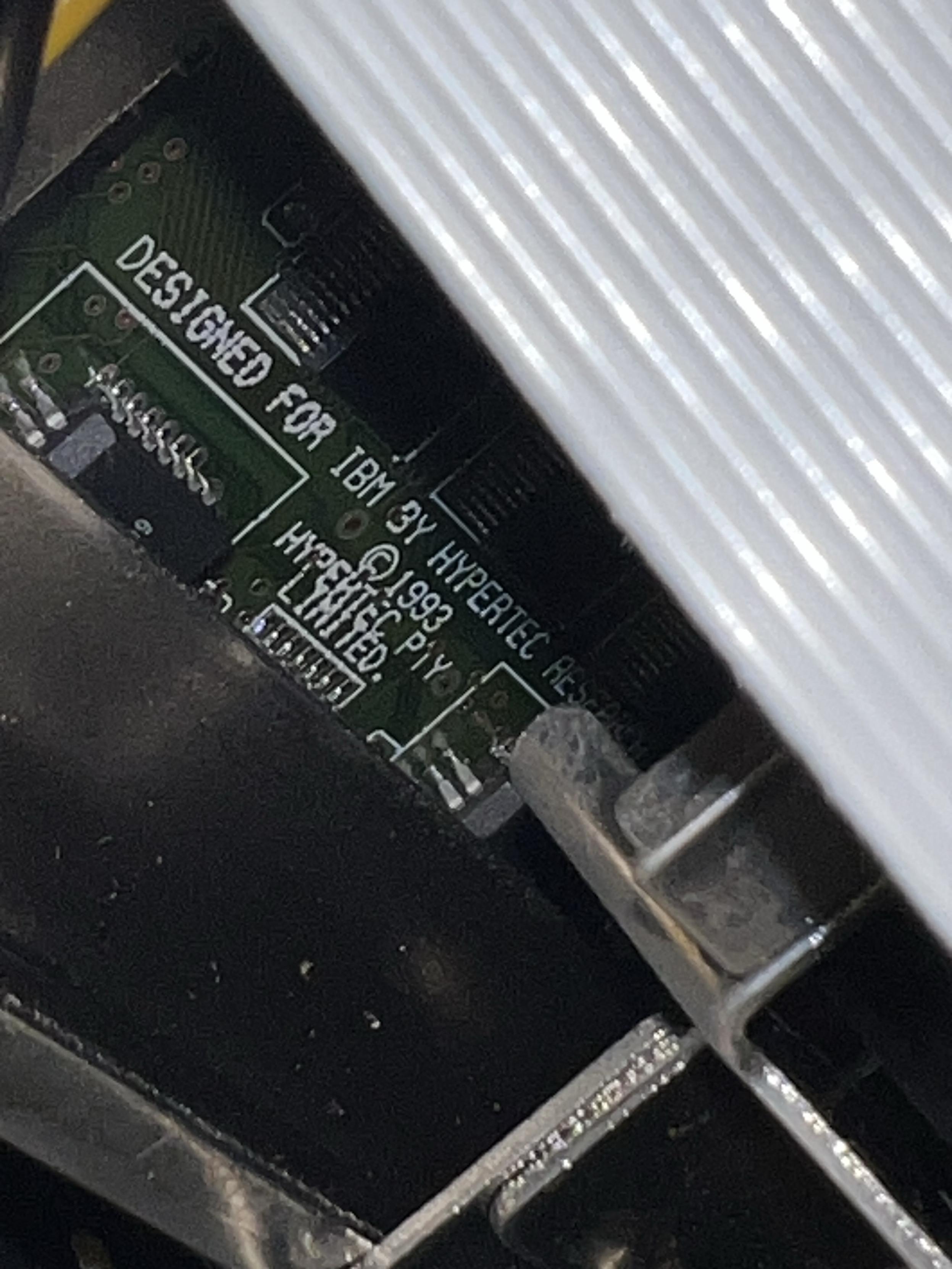 A green circuit board with silk screen in white that reads “DESIGNED FOR IBM BY HYPERTEC”