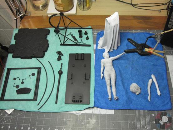 The X-Plus Bride of Frankenstein model kit. In primed sub-assemblies. Base parts in black and Bride parts in Grey/White primer. On a green and blue towel on a workbench.